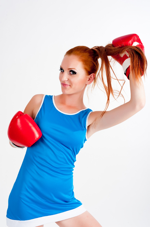 portrait of sports red-hair girl with boxing gloves. isolated on whiteの写真素材