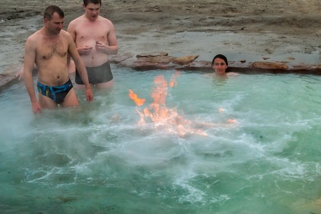 Sungurovo, Russia - May 25, 2008: Mineral water spring Beryozovka. Men rest at geothermal hot water bath with sulfuric gas source. Burning gas. Tyumen regionのeditorial素材