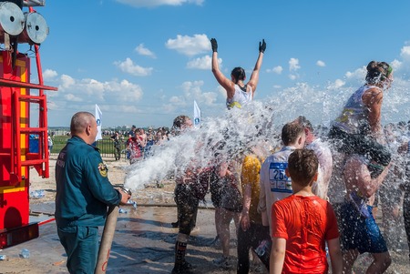 Tyumen, Russia - July 9, 2016: Steel Character extrim race on Voronino Hill. Firefighter pours water from a hose of the wishing athletes after finishingのeditorial素材