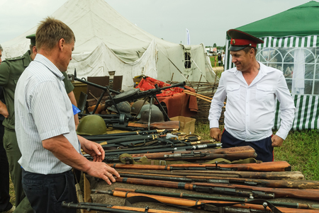 Tyumen, Russia - June 24, 2016: The 5th open championship of Russia on a plowed land. Senior cossack demonstrates rifles collectionのeditorial素材