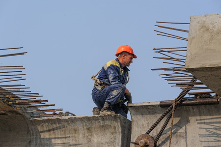 Tyumen, Russia - July 31, 2013: JSC Mostostroy-11. Bridge construction for outcome of the Tobolsk path and Bypass road round Tyumen. Builder works in safety protective equipment on bridge constructionのeditorial素材