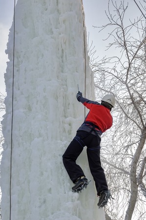 Tyumen, Russia - January 19, 2008: Tower which is filled in with water near Children Club of Kizhevatov name. Ice climbing competition. Man climbs upwardのeditorial素材
