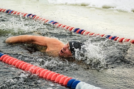 Tyumen, Russia - February 5, 2005: The club of winter swimming holds competitions in the 25 meters ice-hole. Man swimsのeditorial素材