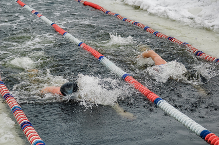 Tyumen, Russia - February 5, 2005: The club of winter swimming holds competitions in the 25 meters ice-hole. Men swimのeditorial素材