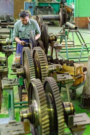 Tyumen, Russia - November 14, 2007: JSC Tyumenskie Motorostroiteli. Plant on production and repair of aviation engines. Mechanic works with part of aviation engineのeditorial素材