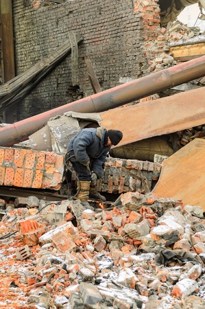 Tyumen, Russia - February 16, 2008: Demolition of machine-tool factory. Worker cutting metal with with acetylene torchのeditorial素材