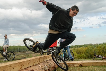 Cyclists jump through a log and fallsのeditorial素材