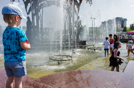 Tyumen, Russia - June 1, 2015: Childrens Day. Kids having fun with fountain shot during summer timeのeditorial素材