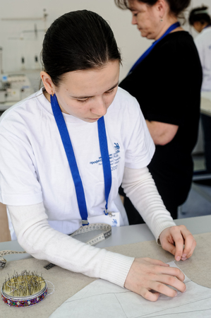 Tyumen, Russia - February 17. 2017: Open championship of professional skill among youth World skills Russia Tyumen - 2017. Tailor measuring necessary amount of material for sewing clothのeditorial素材