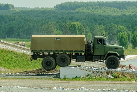 Nizhniy Tagil, Russia - July 12. 2008: Curtain sided KRAZ truck comes around on high obstacle. Display of opportunities of arms and military equipment. RAE exhibition.のeditorial素材