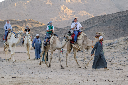 Hurghada, Egypt - November 10, 2006: People ride on camels in tourist villageのeditorial素材