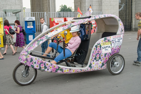 Moscow, Russia - July 3, 2010: Woman on a trishaw expects the passenger on VDNHのeditorial素材