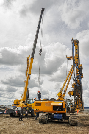 Tyumen, Russia - June 1, 2017: JSC Mostostroy-11. Construction of two-level outcome on bypass road on Fedyuninskogo and Permyakova streets intersection. Construction equipment in actionのeditorial素材