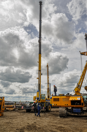 Tyumen, Russia - June 1, 2017: JSC Mostostroy-11. Construction of two-level outcome on bypass road on Fedyuninskogo and Permyakova streets intersection. Construction equipment in actionのeditorial素材