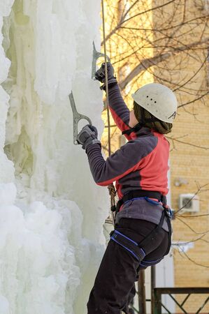 Tyumen, Russia - January 19, 2008: Tower which is filled in with water near Children Club of Kizhevatov name. Ice climbing competition. Girl climbs upwardのeditorial素材