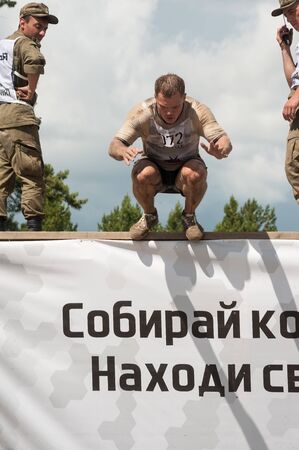 Tyumen, Russia - June 11, 2016: Race of Heroes project on the ground of the highest military and engineering school. Man jump to waterのeditorial素材