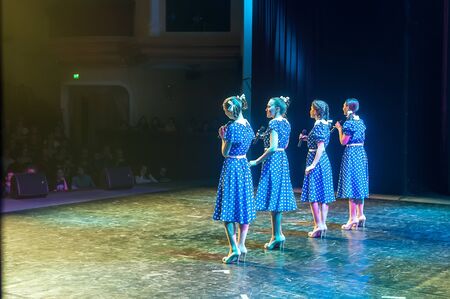 Tyumen, Russia - April 16, 2014: Competition of young performers the Song knows no limit in dramatic theater. Four beautiful female singers singing a song on stageのeditorial素材
