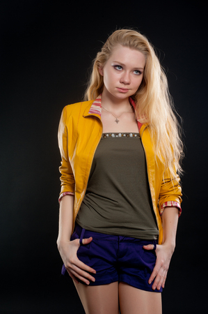 portrait of attractive blond woman in studio at black backgroundの写真素材