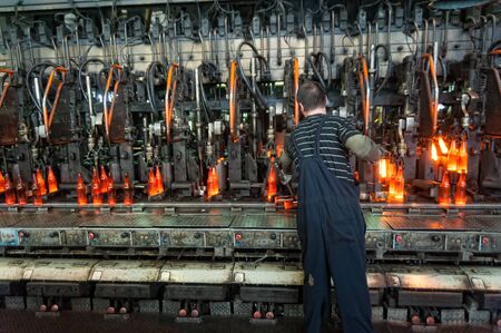 Bogandinskiy, Russia - April 20, 2018: Stekloteh factory on bottles production. Worker controls...