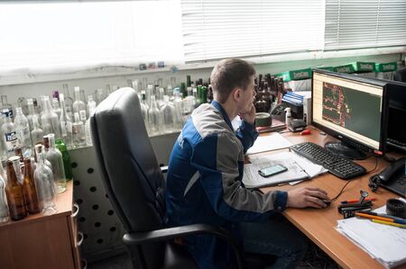 Bogandinskiy, Russia - April 20, 2018: Stekloteh factory on bottles production. Engineer works on PCのeditorial素材