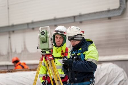 Tobolsk, Russia - May 29. 2018: Sibur company. Construction of plant on processing of hydrocarbons. Surveyor builder worker with theodolite transit equipment at construction site outdoors during surveying workのeditorial素材