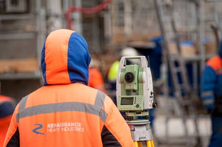 Tobolsk, Russia - May 29. 2018: Sibur company. Construction of plant on processing of hydrocarbons. Surveyor builder worker with theodolite transit equipment at construction site outdoors during surveying workのeditorial素材