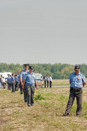 Tyumen, Russia - August 11, 2012: Air show "On a visit at UTair" in heliport Plehanovo. Police officers stand in cordonのeditorial素材