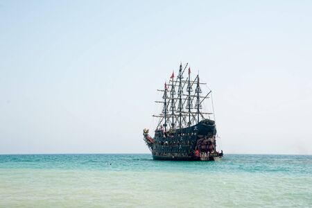 Turkler, Turkey - August 3, 2018: A large white pirate-style sailing ship is moored near the coast against a blue sky. The concept of summer holidays, sports, tourismのeditorial素材