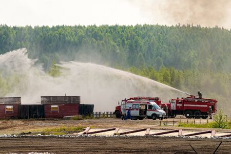 Nizhniy Tagil, Russia - July 12, 2008: Special firefighting vehicle SPM. Display of opportunities of equipment. Russia Arms Expo-2008 exhibition. Firefighter and ambulance team work at fireのeditorial素材
