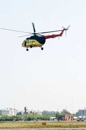 Tyumen, Russia - August 11, 2012: On a visit at UTair airshow in Plehanovo heliport. Rescuer land from MI-8 helicopter for raising of injured personのeditorial素材