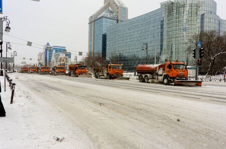 Tyumen, Russia - December 17, 2018: Respubliki street with Gazprom building. Snowplows removing snow in street after blizzardのeditorial素材
