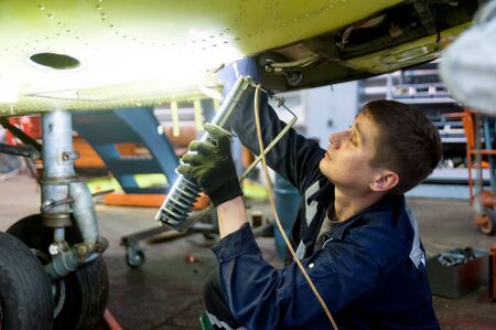 Tyumen, Russia - June 5, 2019: Aircraft repair helicopter UTair Engineering plant. Worker maintaining a Mi-8 helicopterのeditorial素材