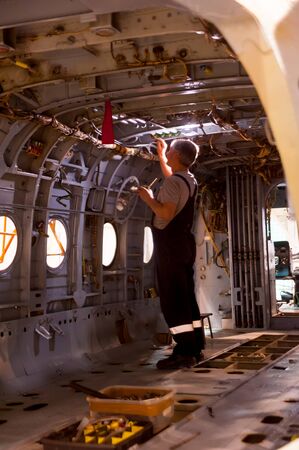 Tyumen, Russia - June 5, 2019: Aircraft repair helicopter UTair Engineering plant. Worker maintaining a Mi-8 helicopterのeditorial素材