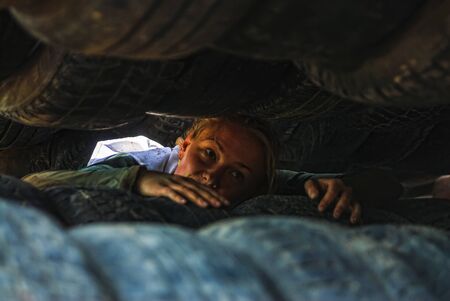 Tyumen, Russia - June 11, 2016: Race of Heroes project on the ground of the highest military and engineering school. Woman moves between old tires. Born again stageのeditorial素材