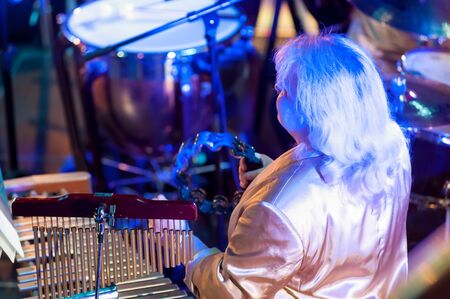 Tyumen, Russia - April 16, 2014: Competition of young performers the Song knows no limit in dramatic theater. Orchestra with musical instruments. Woman plays on xylophone and tambourineのeditorial素材