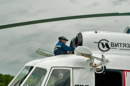 Tyumen, Russia - June 19, 2019: Aircraft repair helicopter UTair Engineering plant. Male mechanic in uniform examining helicopter. Pre flight inspection at the airportのeditorial素材