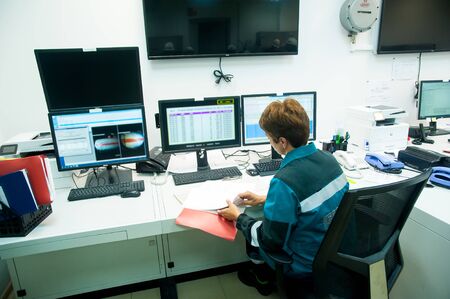 Tobolsk, Russia - July 23. 2019: Sibur company. Plant on processing of hydrocarbonic raw materials. Woman in industrial control room monitors operation of the equipmentのeditorial素材