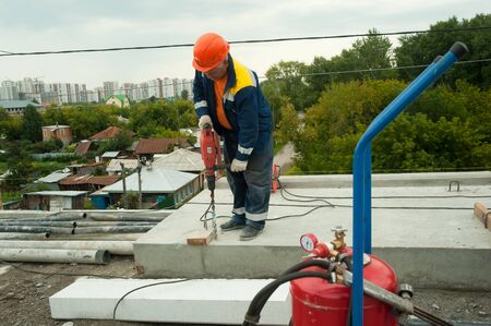 Tyumen, Russia - September 4, 2019: JSC Mostostroy-11. Bridge reconstruction on Chelyuskincev street. Manual worker drilling concreteのeditorial素材