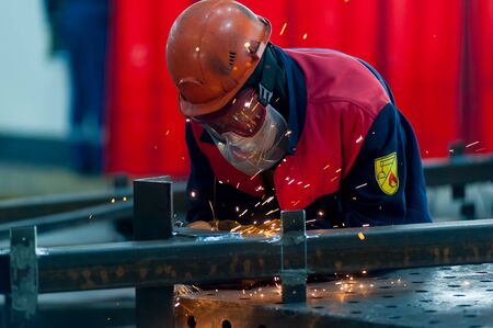 Tyumen, Russia - September 4, 2019: Mostootryad-36 Factory. Heavy industry worker cutting steel pipe...
