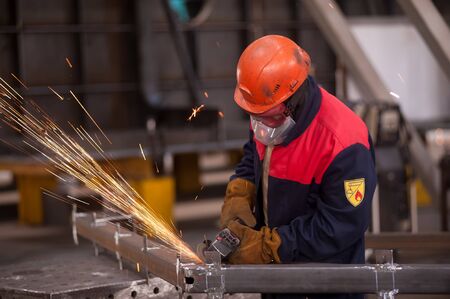 Tyumen, Russia - September 4, 2019: Mostootryad-36 Factory. Heavy industry worker cutting steel pipe...
