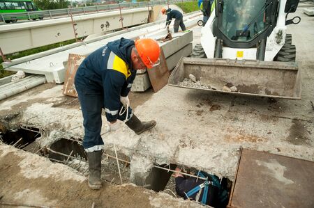 Tyumen, Russia - September 4, 2019: JSC Mostostroy-11. Bridge reconstruction on Chelyuskincev street. Workers remove construction debrisのeditorial素材