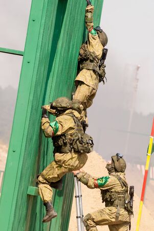 Tyumen, Russia - August 11, 2019: International Army Games. Safe Route contest. Military officers climbing on wall during obstacle courseのeditorial素材