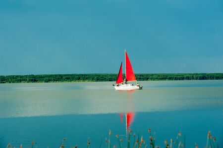 Tyumen, Russia - June 30. 2017: Andreevskoe lake. Sailing boat on a calm lake with reflection in the waterのeditorial素材