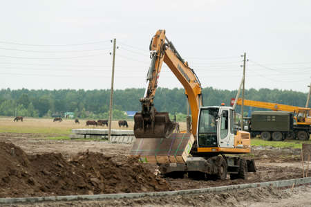 Tyumen, Russia -August 13, 2019: Construction of a highway junction on Fedyuninsky street. Big excavator on construction siteのeditorial素材