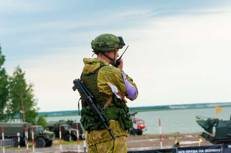 Tyumen, Russia - August 11, 2019: International Army Games. Safe Route contest. Highest military and engineering school ground. Officer holds radio station and give orders subdivisionのeditorial素材