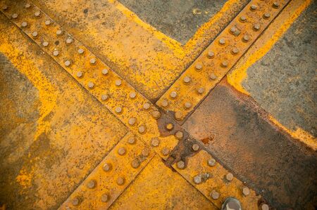 Antique rusty metal square nuts locked with rust and corrosion on old heavy duty bolts holding a...