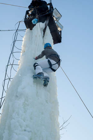 Tyumen, Russia - January 19, 2008: Tower which is filled in with water near Children Club of Kizhevatov name. Ice climbing competition. Girl climbs upwardのeditorial素材