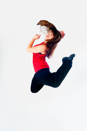 Happy beautiful slim woman jumping over white backgroundの写真素材