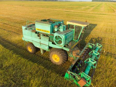Tyumen region, Russia - August 22, 2021: Aerial view on the combine working on the large...