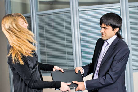 Young woman amd man argue for notebook